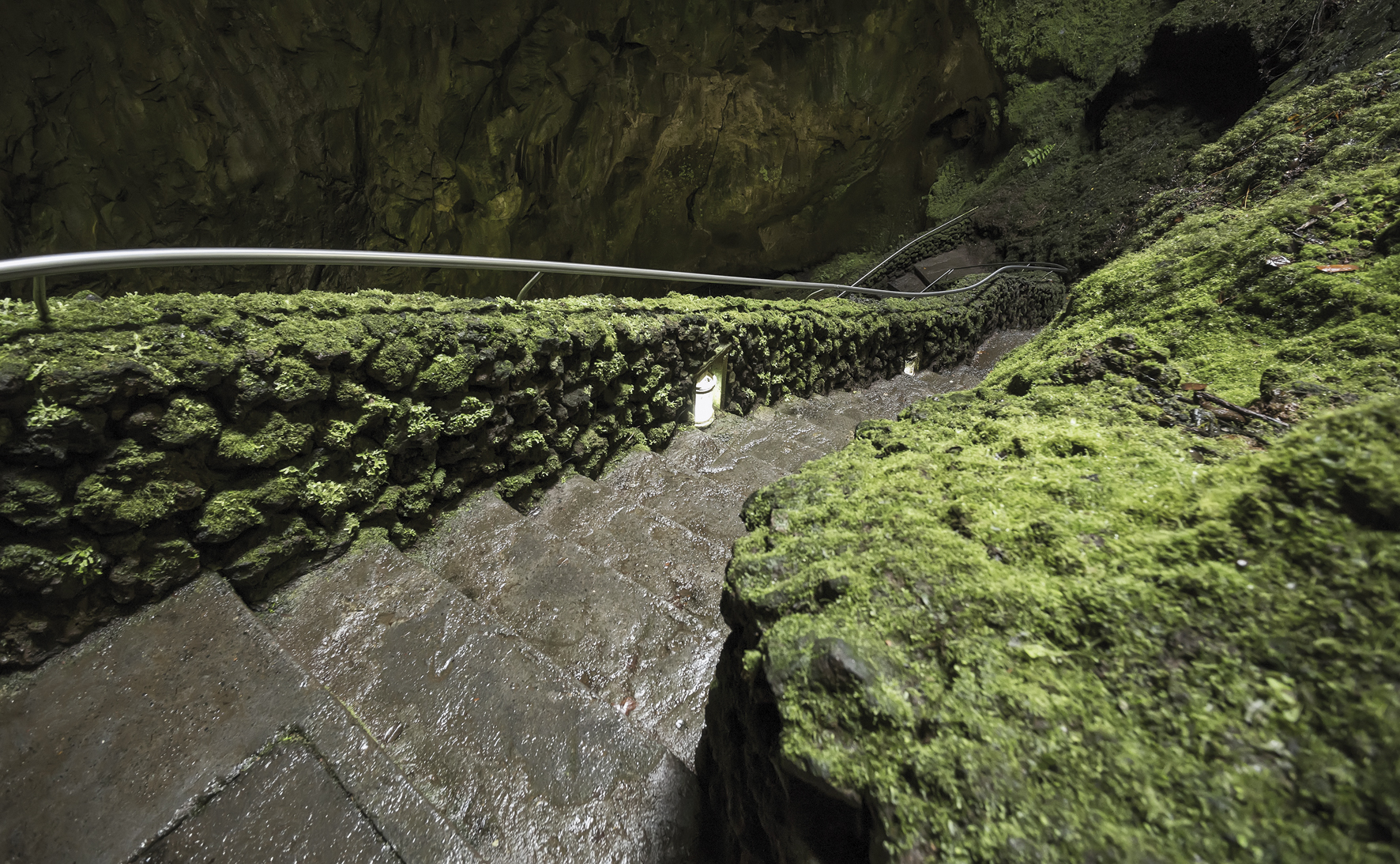 Eine Treppe, die in das Innere der Vulkanhöhle Algar do Carvão auf der Insel Terceira führt